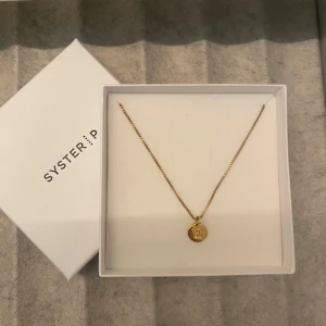 Guldhalsband med berlocken E - Säljer för kommer inte till användning, då jag fick en likadan i konfirmations present. Aldrig använt. Man köper berlocken och kedjan separat på hemsidan, men säljes tillsammans för 550kr. Både kedjan och berlocken är pläterad med 18 k guld.