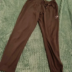 Gymshark Byxor - Höj din träningsnivå med dessa gymshorts från Gymshark! Designade för optimal passform och komfort, erbjuder de både stil och funktion. Helt nya och perfekta för alla dina träningspass. Missa inte chansen att förbättra din workout-look!