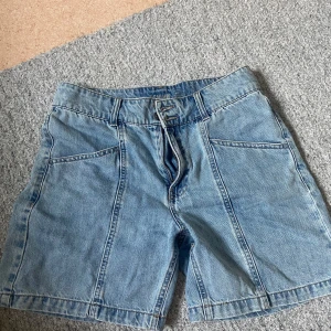 Blå jeansshorts med dragkedja - Säljer ett par klassiska blå jeansshorts från Denim. De har en snygg dragkedja och knappar framtill, samt två stora fickor bak. Perfekta för sommaren och passar till nästan allt! 🩳💙