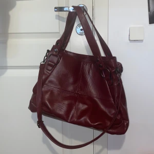 Vinröd väska - 39cm bred, 11cm djup och 27cm hög. Perfekt som skolväska🫶