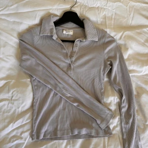 Grå Gina Tricot Basic Long sleeve top - Normal i storlek. Endast använd väldigt få gånger. I utmärkt skick. Grå långärmad pikétröja. Long sleeve polo shirt. Långärmad t-shirt. Gina basically basic. Gina basic. Gina tricot