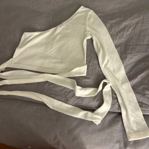 Vit tröja med band. - En vit långärmad tröja som du knyter på magen. Den är använd 1 gång och är mycket god skick. Storleken är S.