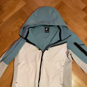 Baby blue tech fleece - En baby blue Nike tech fleece i strlk s. Den har ett litet hål vid armen och     en fläck på bröstet men annars fint skick. Frakt 80kr