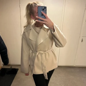 Beige kappa - Beige kappa från Nelly, strl 36, sparsamt använd ( inga fläckar osv ) använd ett fåtal gånger. Köpt för 300kr