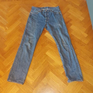 Levi's 501 jeans - Säljer ett par klassiska Levi's 501 jeans i blå denim. De har en rak passform och är i bra skick. Perfekta för en avslappnad stil och passar till det mesta. Storlek W34 L36.