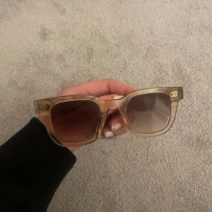 Solglasögon från Chimi - Snygga solglasögon från Chimi i en cool beige färg. De har en fyrkantig form och är perfekta för både vardag och fest. Glasögonen är i mycket bra skick och har en stilren design