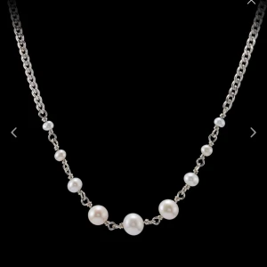 Maria Nilsdotter halsband - Elegant silverhalsband med vita pärlor i olika storlekar. Perfekt för att ge en klassisk touch till din outfit. Kedjan är i silver och pärlorna är jämnt fördelade för en stilren look. Passar både till vardag och fest! Nypris: 3200kr 