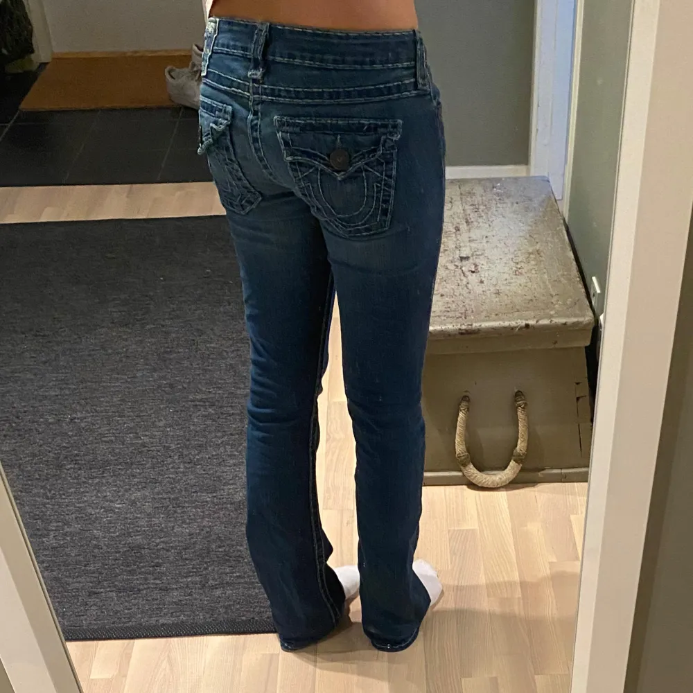 Säljer mina lågmidjade bootcut true religion jeans💕 Midjemåttet rakt över:39cm Innerbenslängden:83cm De har inga defekter förutom några få saknade sömmar längst ned på vänstra benet (se bild 5) men inget som märks!❤️ Skriv för frågor eller bilder!. Farkut & Housut.