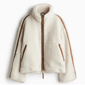 Teddy jacka H&M - 💗INTRESSEKOLL💗Supermysig vit teddyjacka med bruna detaljer och dragkedja framtill från H&M. Perfekt för kyliga dagar med sin fluffiga och varma design. Jackan har en hög krage och långa ärmar, vilket gör den idealisk för höst och vinter. Den har en avslappnad passform och är både stilren och bekväm.