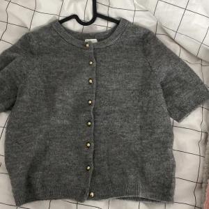 T-shirt kofta med guldiga knappar - En super fin kofta med guldiga knappar, från H&M, säljer för att den inte kommer till användning längre, använt 3-4 ggr💞