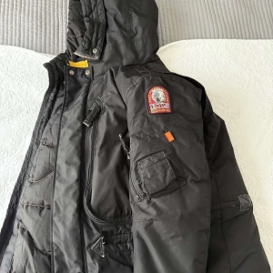 Parajumper - Säljer en svart vinter jacka från parajumper i mycket bra skick jackan har en qulitad insida och flera praktiska fickor med dragkedjor den har en huva som stäng med både dragkedja och knappar perfekt nu till vinterdagar!