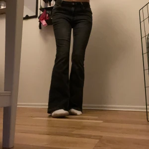 Svarta bootcut jeans - Säljer ett par snygga svarta bootcut jeans i mycket bra skick. De är lågmidjade och har en klassisk ”femficksdesign” med knappar och dragkedja. Perfekta för både vardag och fest! 🖤