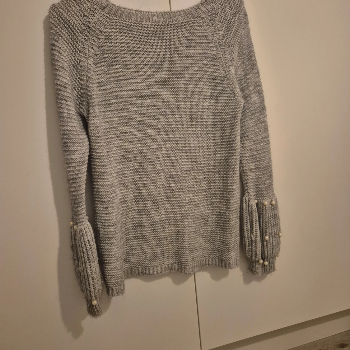 Grå stickad tröja med pärldetaljer