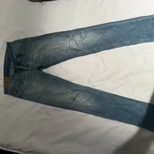 Säljer ett par snygga blå jeans från Dondup i storlek 29. De har en cool slitning på framsidan och en klassisk femficksdesign. Perfekta för en avslappnad stil och passar till nästan allt. De är i bra skick och redo för nya äventyr! 🕺