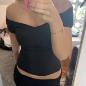 Svart offshoulder topp från Nelly - Säljer en snygg svart offshoulder topp från Nelly i storlek XS. Toppen är tight och perfekt för festliga tillfällen. Den har en stilren design med korta ärmar och en smickrande passform. Perfekt att matcha med jeans eller kjol för en chic look! använt 2 gånger men känner att den inte passar mig längre! 