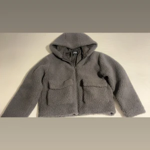 Teddy jacka - En trendig teddy jacka med luva från zara kids i färgen grå! Den är lite stor så jag tror den skulle kunna passa xxs, 152 Köpte den förra året i höstas. Den är i nyskick med inga defekter!