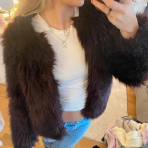 Fuskpälsjacka - Säljer en superfin vinröd/brun pälsjacka i mycket bra skick. Den är perfekt för höst och vinter och har en mysig, fluffig känsla. 