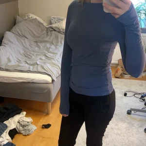 Blå långärmad tröja - Säljer en snygg blå långärmad topp i mycket bra skick. Den är ganska tight och materialet känns mjukt och stretchigt, vilket gör den superbekväm att ha på sig. 