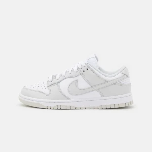 Vita Nike Dunk sneakers - Säljer ett par fräscha vita Nike Dunk sneakers i nytt skick. De har en klassisk design med snörning och är perfekta för både vardag och träning. Skorna är gjorda i skinn och har en bekväm passform. Har en liten fläck på ena skosnöret och därav sänkt pris. PMa för bild. Nypris 1245kr. 