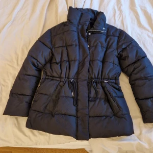 Vinterjacka  - Vinterjacka ifrån bubbelroom. Knytning i midjan och högkrage.  En knapp på ena fickan har ramlat av (se bild), ut över de har jackan inga anmärkningar. Använt 1-2 säsonger.