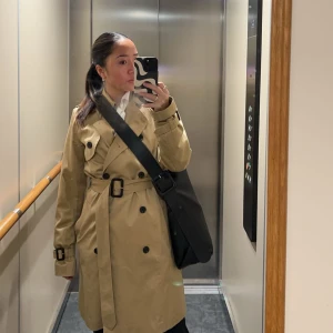 Trenchcoat - En klassisk trenchcoat från Esprit i tjockare tyg med alla de klassiska detaljerna. I 100% bomull. Använt men i väldigt fint skick. 2 sido-fickor & en innerficka.