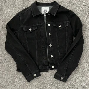 Svart jeansjacka - Fin svart jeansjacka, nästan helt oanvänd. Den är väldigt liten i storleken.