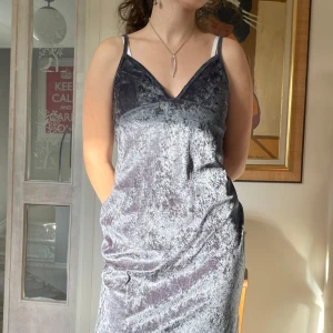 Mörkgrön klänning  - Kort mörkgrön klänning i sammet. Går ungefär till knäna. 