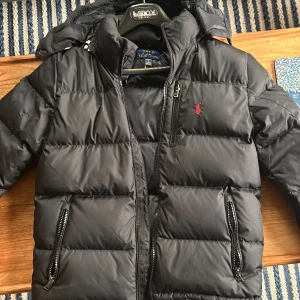 Svart polo puffer - Perfekt svart Ralph lauren puffer inför vintern i storlek L | skick 9/10 | avtagbar luva | skicka vid minsta fråga och prisförslag är alltid välkomna  