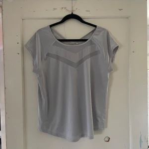 Grå topp från Ergee - Säljer en stilren grå topp från Ergee i storlek XXL. Toppen har korta ärmar och en v-ringad design med subtila detaljer som ger en modern touch. Perfekt för både vardag och avslappnade tillfällen.