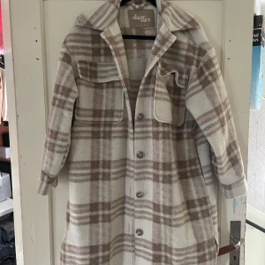 Rutig overshirt från Shacket - Säljer en superfin rutig overshirt från Shacket. Den är i en snygg beige och brun färgkombination med stora rutor. Perfekt för höst och vår! Den har långa ärmar och knappar framtill. Två stora fickor på bröstet ger den en cool look.