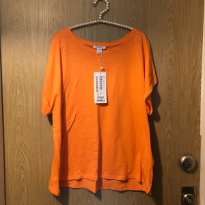T-shirt Dam  - Strl L med prislapp kvar. Med vikta ärmar & slits nertill. 