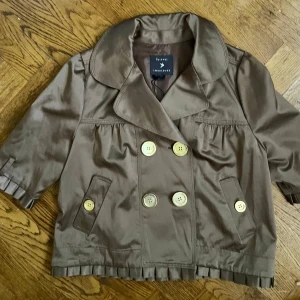 Brun jacka från Forever 21 - Säljer en snygg brun jacka från Forever 21. Den har en dubbelknäppt design med stora knappar och en bred krage. Jackan är kortärmad perfekt för höst och vår. 