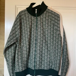Lacoste Zip Shirt - En fet Lacoste Zip i bra skick. Inprincip aldrig använd enbart nån fåtal gång. Den är som ny. Ganska liten i storleken sitter som en M/L