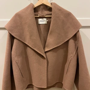 Stylein kappa - Hej, säljer denna fina beiga kappa från Stylein. Har varit mycket sparsamt använd. Inköpt för 5000kr och är i Storlek S. Hör av dig vid frågor!❣️jag är villig att diskutera pris!