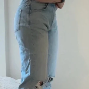 Ljusa jeans med slitningar - Snygga ljusblå jeans med hög midja och slitningar vid knäna. Perfekta för en avslappnad stil.