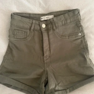 Olivgröna shorts från Perfect Jeans - Snygga olivgröna shorts från Perfect Jeans i modellen Molly. De är högmidjade med klassisk femficksdesign och knappgylf. Perfekta för en avslappnad stil.