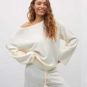 Vit offshoulder tröja - Säljer en stilren vit offshoulder tröja med en avslappnad passform. Tröjan är tillverkad i ett mjukt material och har långa ärmar. Perfekt för en bekväm och trendig look. Helt ny från Gina 