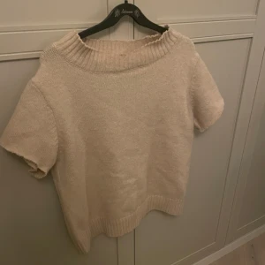 Beige stickad tröja - Mysig beige stickad tröja med korta ärmar och en bred ribbad krage. Perfekt för en avslappnad stil och passar bra till både jeans och kjol. Enkelt och stilrent plagg för alla tillfällen💕💕