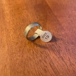 Glittrig silverring - Snygg och stilren ring i silver med en glittrig yta. Perfekt för att ge lite extra bling till din look. Ringen är i storlek 19 och passar utmärkt för både vardag och speciella tillfällen.