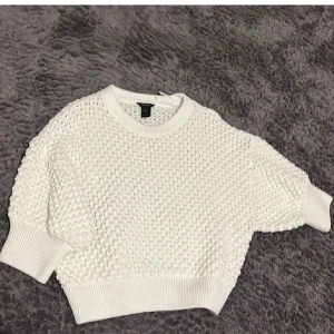Vit stickad tröja från Lindex - Säljer en stilren vit stickad tröja från Lindex . Tröjan är virkad med hål och är benvit.
