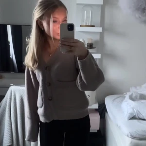 Beige kofta med knappar - Säljer en mysig beige kofta med stora knappar framtill. Koftan har långa ärmar och en avslappnad passform, perfekt för kyligare dagar. Den är enkel att matcha med olika outfits och ger en stilren look.          Fint skick och inga skador, inget nopprigt heller ❤️