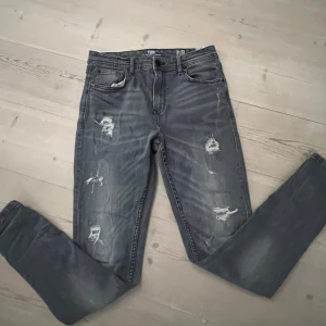 Grå jeans med slitningar - Säljer dessa Snygga grå jeans från FSBN med coola slitningar. Väldigt bra skick! Stlk 31/323).   Hör av er vid frågor!