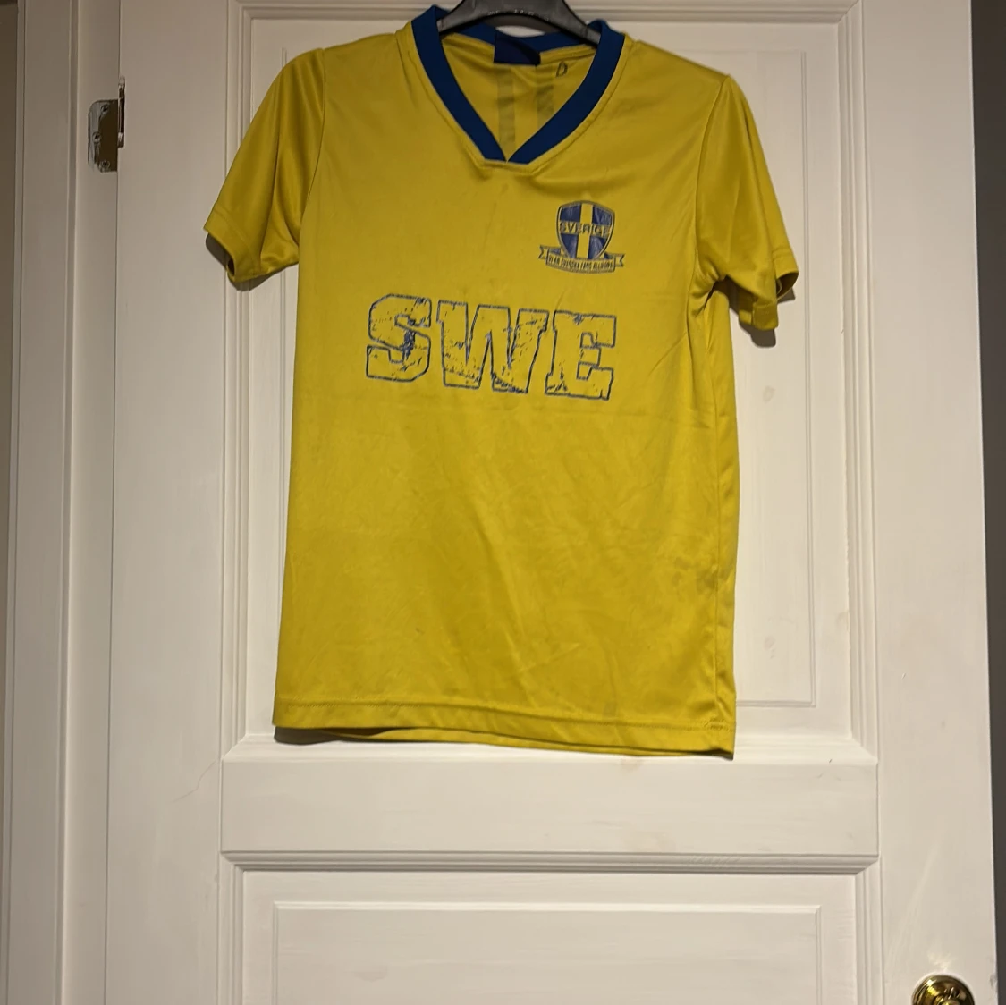 Gul fotbollströja med blå detaljer