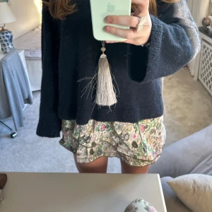 Blommig kort kjol med volang - Söt blommig ZADIG kort kjol med volangdetaljer. Perfekt för en avslappnad och stilfull look. Kjolen har en lekfull design med ett färgglatt mönster.