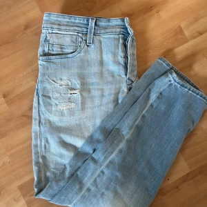 Jack&jones jeans, slim/glenn - Sköna ljusblåa jeans från Jack & Jones med slitningar på framsidan. Byxorna har en slim passform  