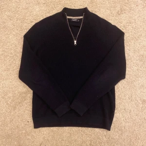 Mörkblå kaschmir half-zip från Holebrook - Säljer en stilren mörkblå tröja från Holebrook i extra fin merinoull, nästintill kaschmir. En quarterzip som går att vika ner eller låta stå. Den passar även storlek M. Perfekt för kyliga dagar!