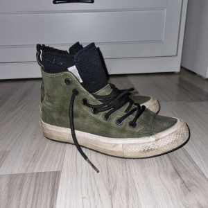 Gröna Converse All Star sneakers - Säljer ett par gröna Converse All Star sneakers med svart snörning och hög modell. Skorna har en klassisk vit sula med svart rand och Converse-logga på sidan. Perfekta för en avslappnad stil. De är fodrade så passar utmärkt till vår- och höst.