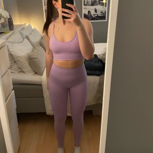 Lila träningsset - Säljer ett snyggt lila träningsset i storlek XS med en croppad linnetopp och matchande tights. Perfekt för gymmet. Setet är i ett mjukt och stretchigt material som ger en bekväm passform.