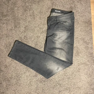  EDC by ESPRIT Jeans grå - Snygga grå jeans med en lätt slitningseffekt av märket EDC by ESPRIT i slim fit. De har en klassisk femficksdesign och en bekväm passform. Perfekta för en avslappnad stil. Storlek 34/32.