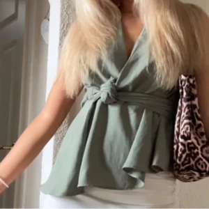 blus med knytning - Snygg grön ärmlös blus med knytning i midjan. Den har en omlott-design, man kan knyta den på olika sätt🥰super gullig till allt